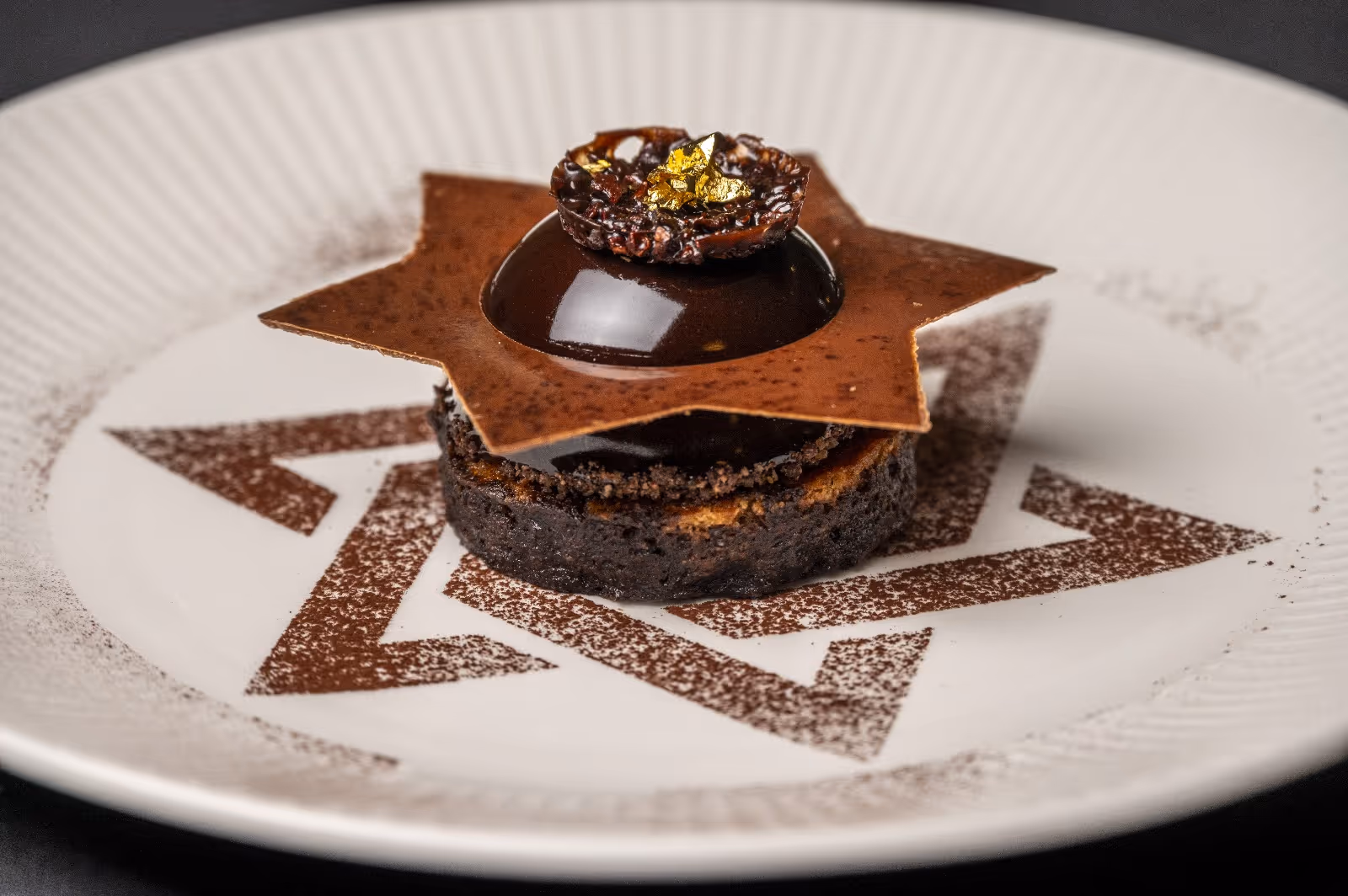 Postre elegante de chocolate con hoja dorada y diseño artístico en plato