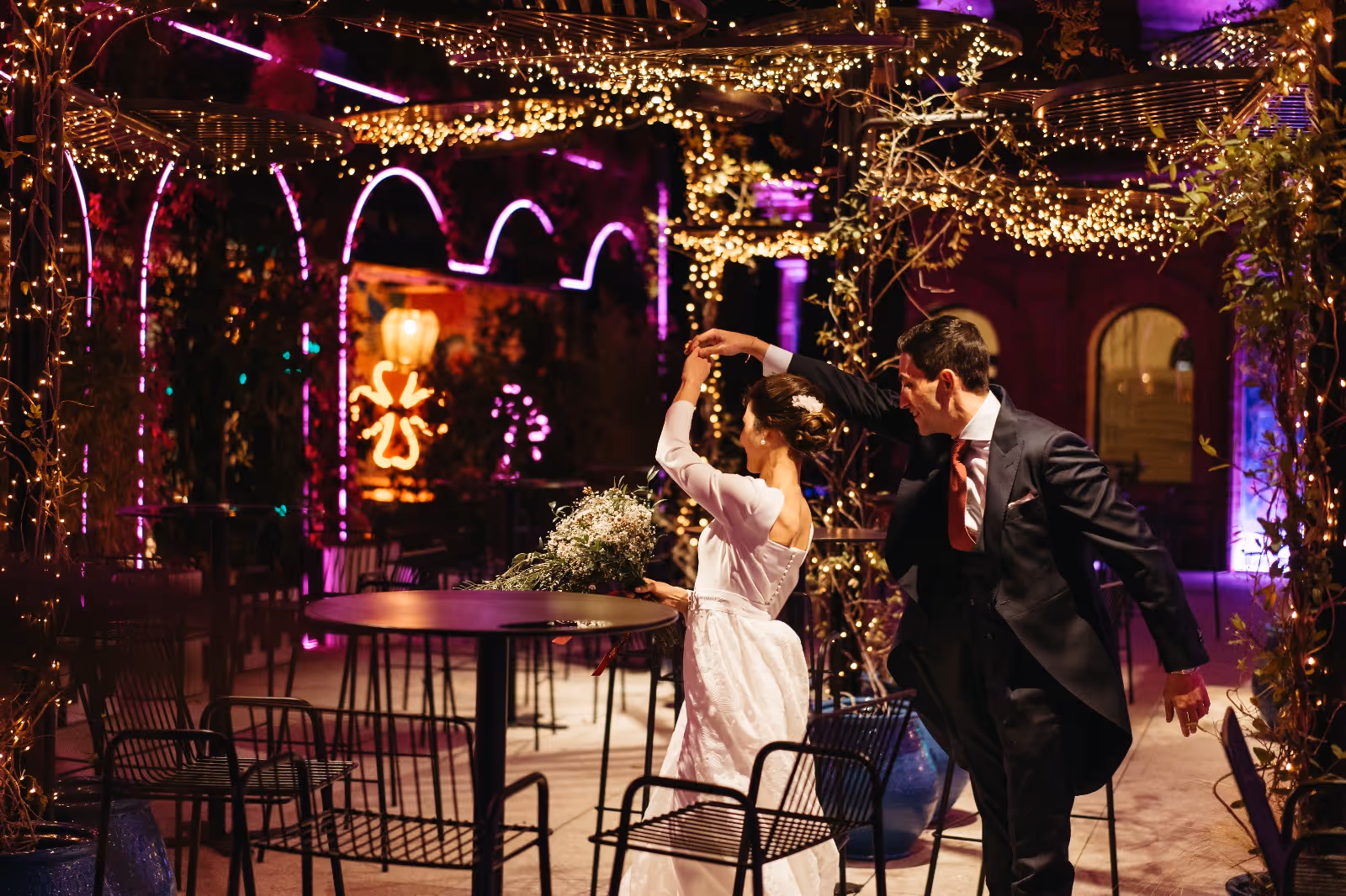 Pareja de boda bailando en un lugar iluminado con luces brillantes